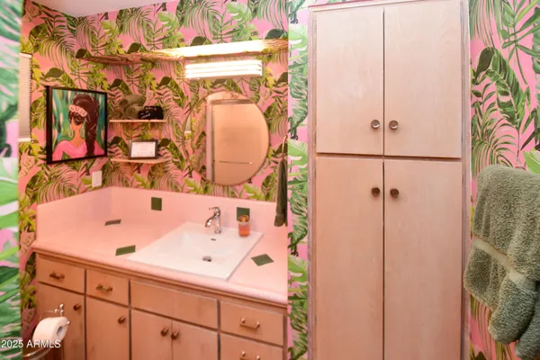 a bathroom with a sink and mirror with toilet
