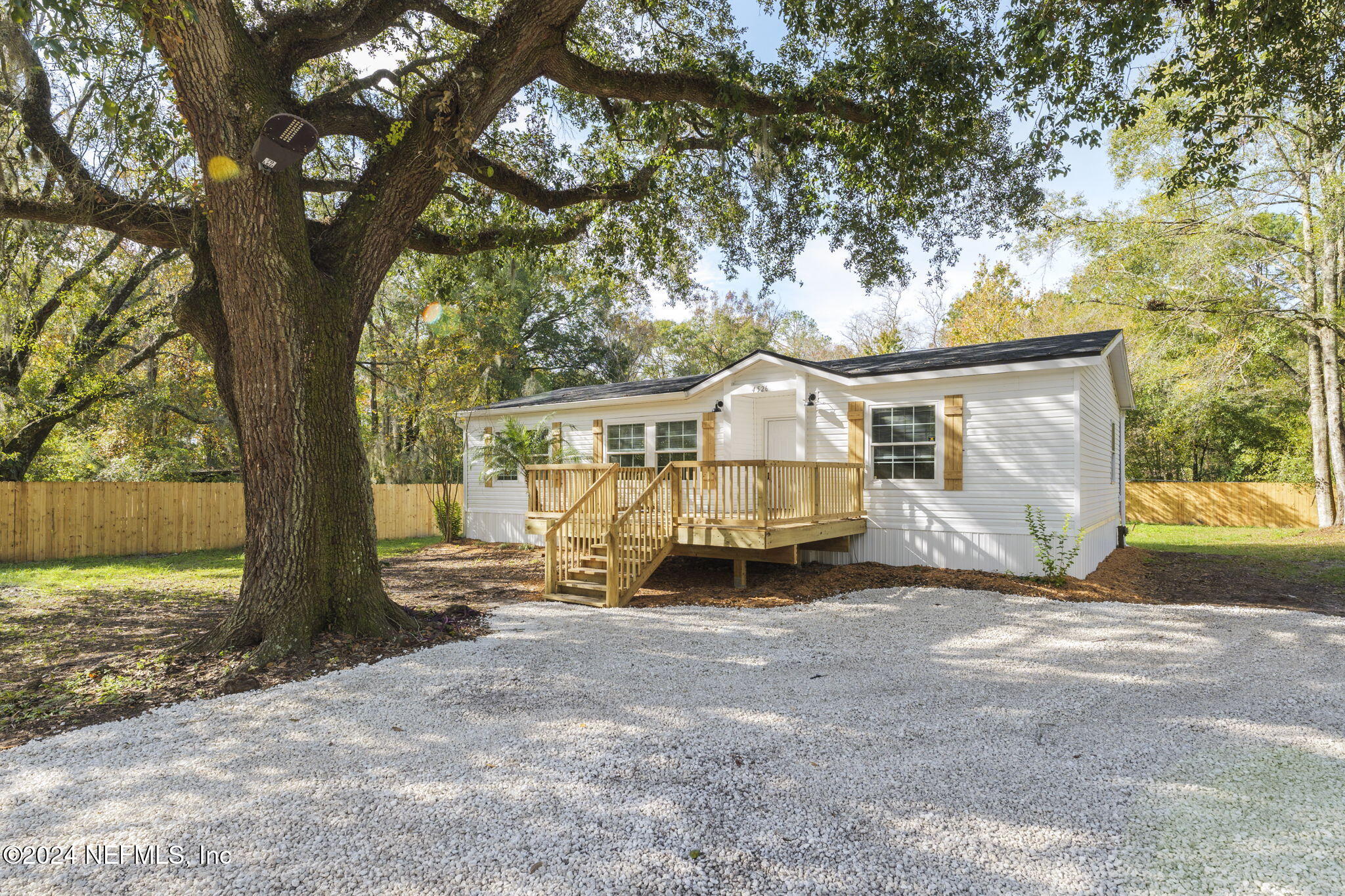 a view of a house with backyard and a tree