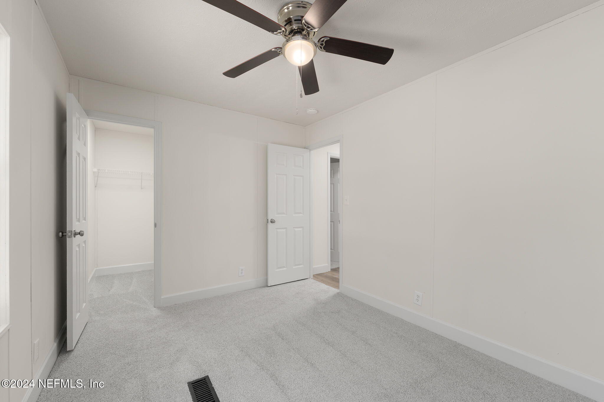 4526 Lambing Road Jacksonville, FL 32210 - Photo 16 of 32 an empty room with closet and a chandelier fan