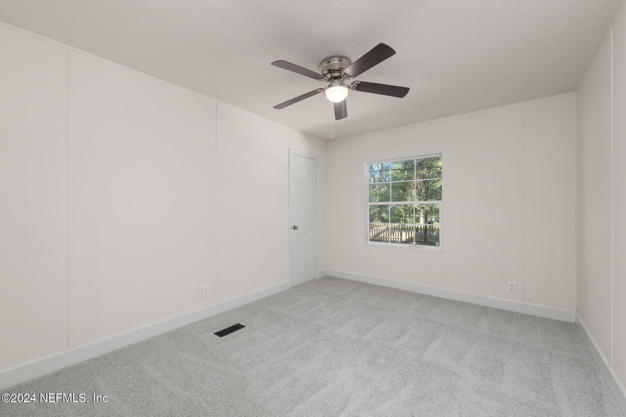 4526 Lambing Road Jacksonville, FL 32210 - Photo 19 of 32 an empty room with windows and fan