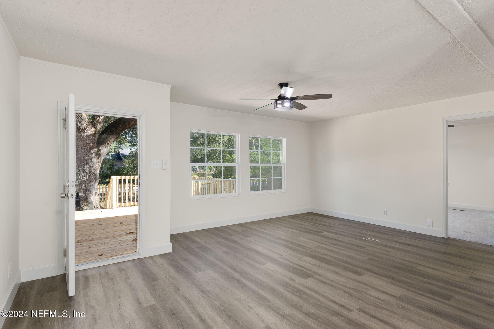 4526 Lambing Road Jacksonville, FL 32210 - Photo 9 of 32 a view of an empty room with wooden floor and a window