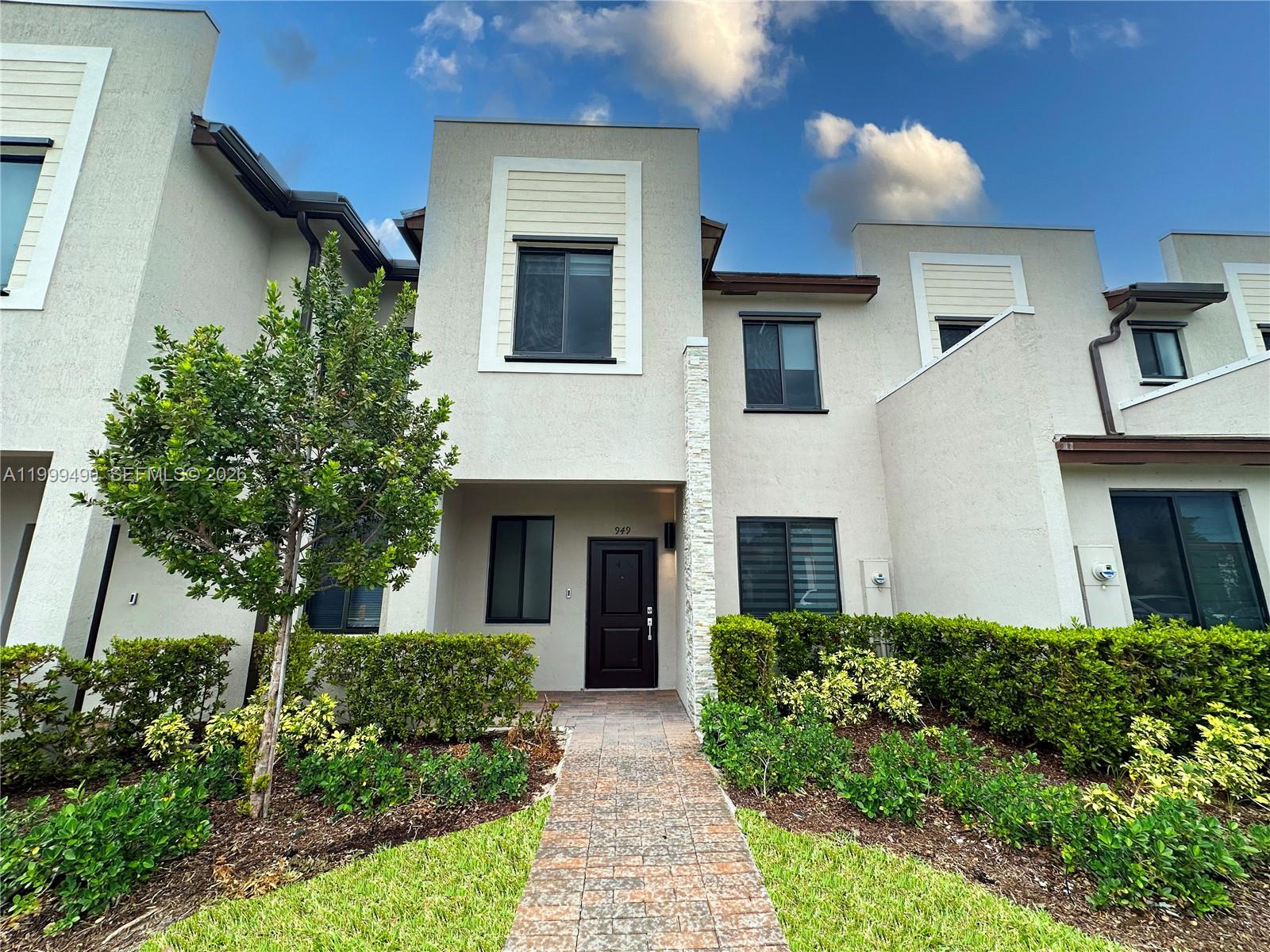 a front view of a house with yard and green space