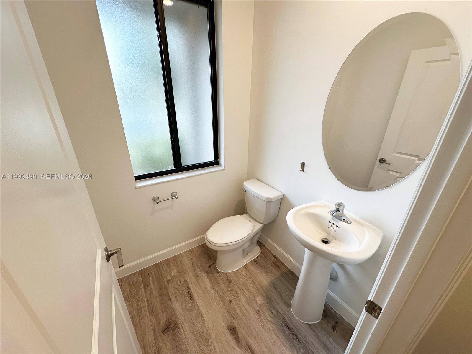 949 Northeast 211th Street Miami, FL 33179 - Photo 4 of 27 a bathroom with a toilet sink and mirror