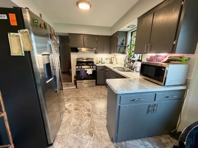 a kitchen with a refrigerator microwave and sink