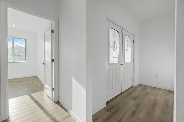 a view of a hallway with wooden floor and closet
