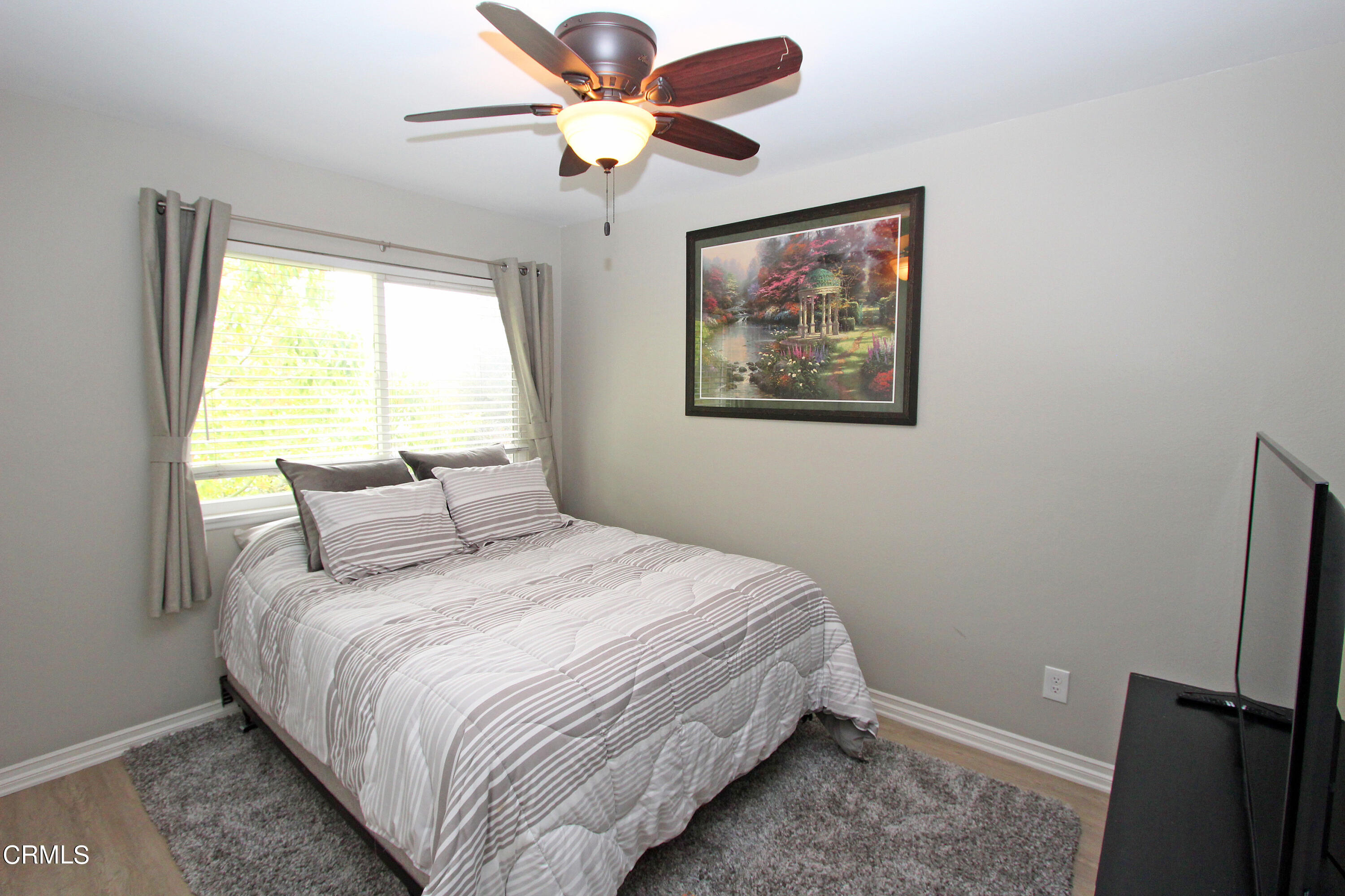 15030 Reedley Street, Unit C Moorpark, CA 93021 - Photo 25 of 51 a bedroom with a bed and a painting on the wall
