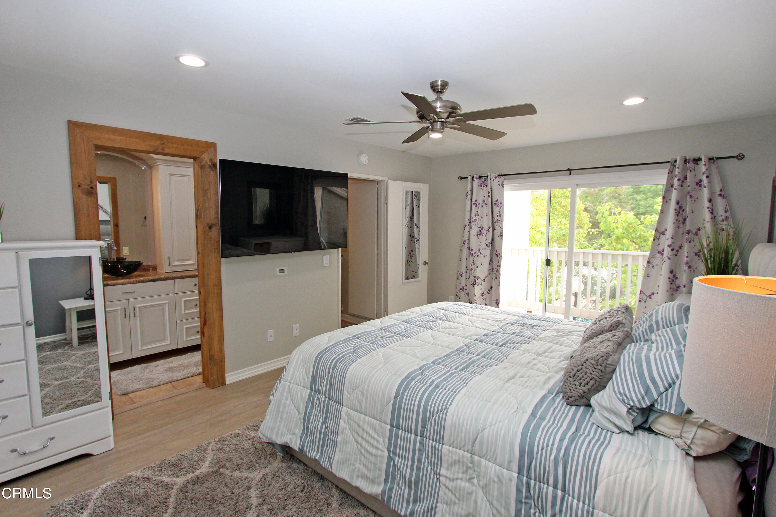 15030 Reedley Street, Unit C Moorpark, CA 93021 - Photo 35 of 51 a spacious bedroom with a bed and a flat screen tv