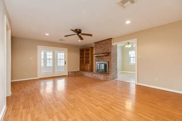 a view of empty room with wooden floor and fireplace