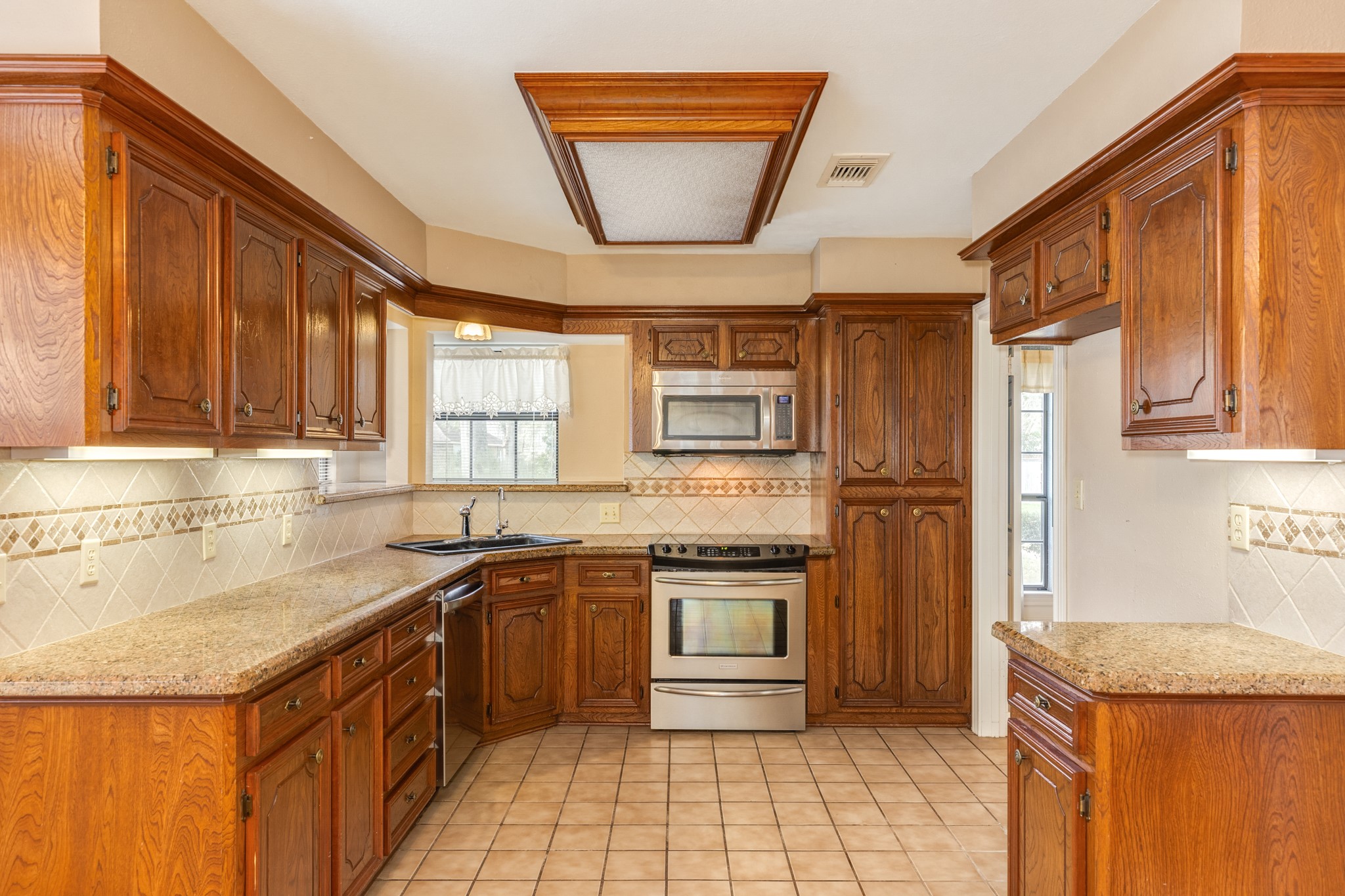 212 Any Way Street Lake Jackson, TX 77566 - Photo 5 of 28 a kitchen with stainless steel appliances granite countertop a sink stove and refrigerator