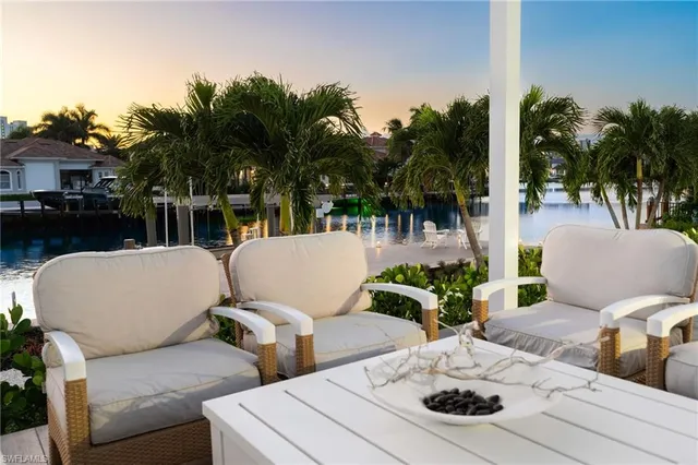 a view of a patio with table and chairs potted plants and palm tree