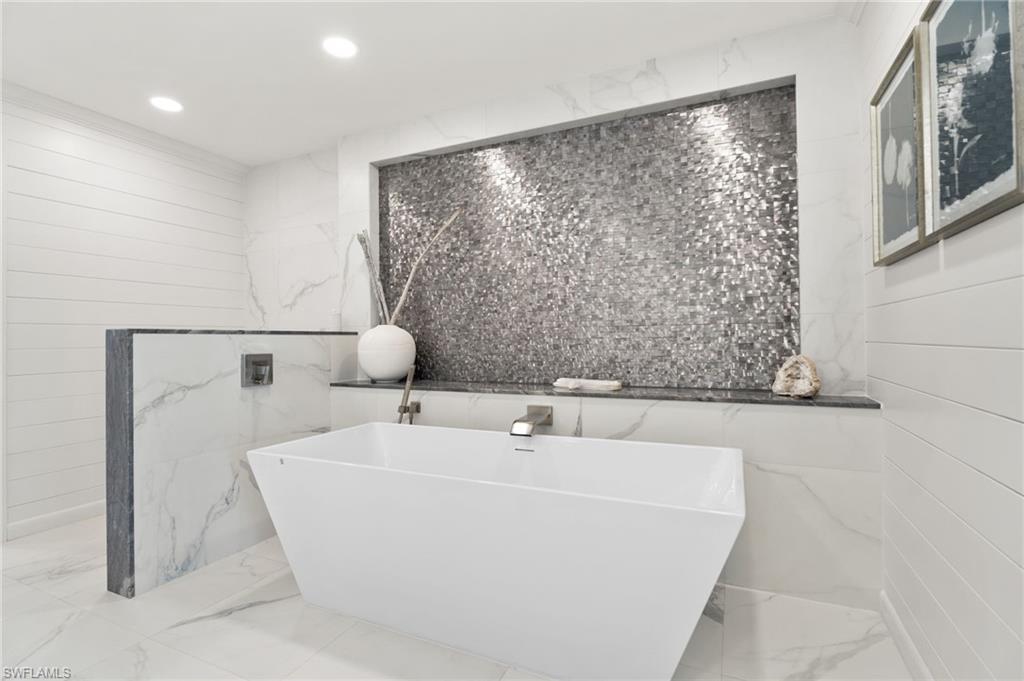 3737 Crayton Road Naples, FL 34103 - Photo 14 of 33 a bathroom with a bathtub and shower