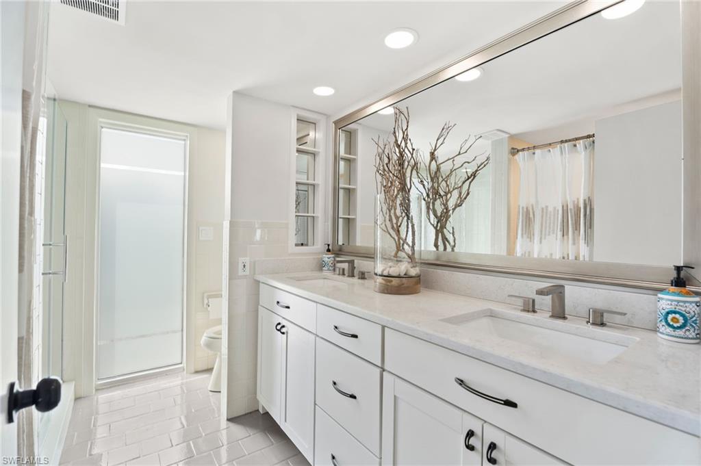 3737 Crayton Road Naples, FL 34103 - Photo 22 of 33 a bathroom with a double vanity sink and a mirror