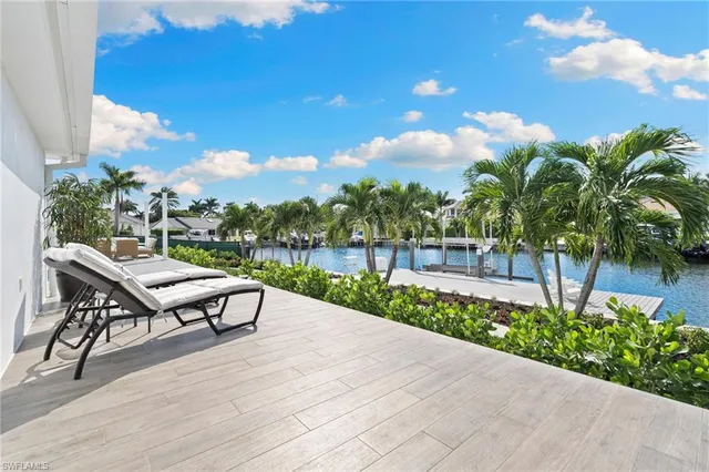 a roof deck with table and chairs plants and wooden fence