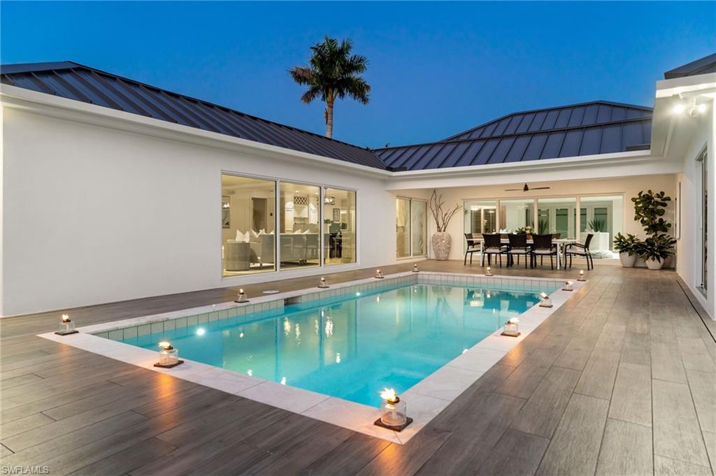 3737 Crayton Road Naples, FL 34103 - Photo 3 of 33 a view of a swimming pool with outdoor seating