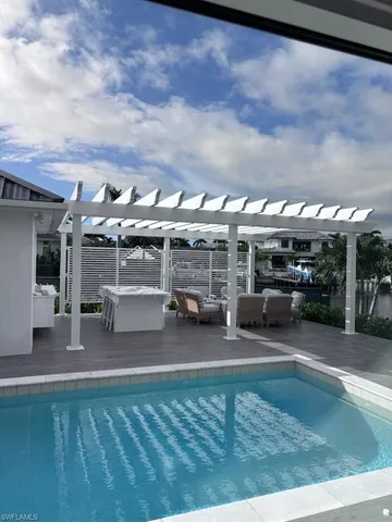 a view of a patio with couches table and chairs with wooden floor