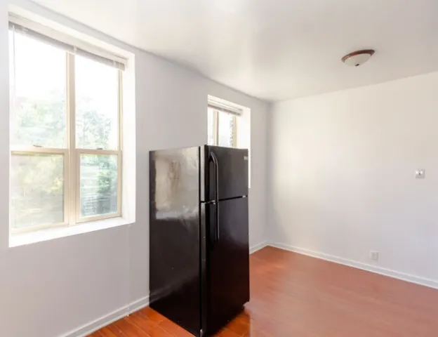 a view of a refrigerator in kitchen and a window