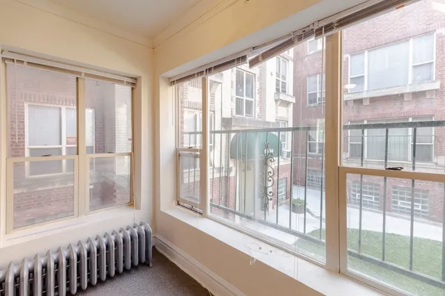 a bedroom with a bed and a large window
