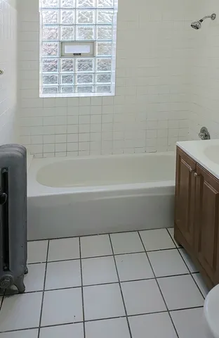 a bathroom with a bathtub a window and a shower