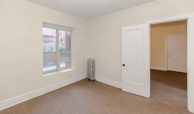 an empty room with windows and closet
