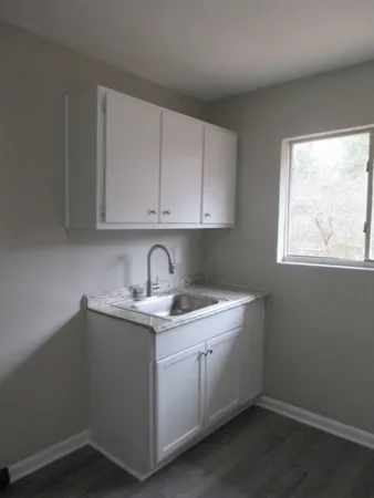 a room with a sink cabinets and utility