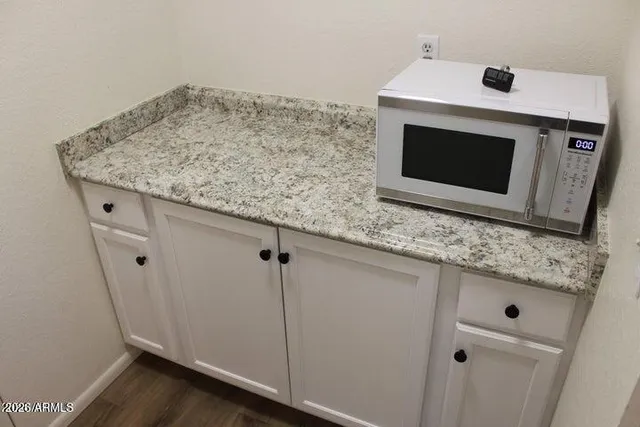 a utility room with granite countertop cabinets washer and dryer