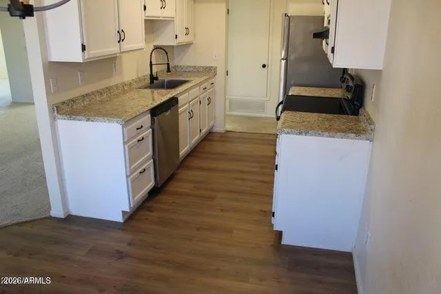 a kitchen with kitchen island granite countertop wooden cabinets and a sink