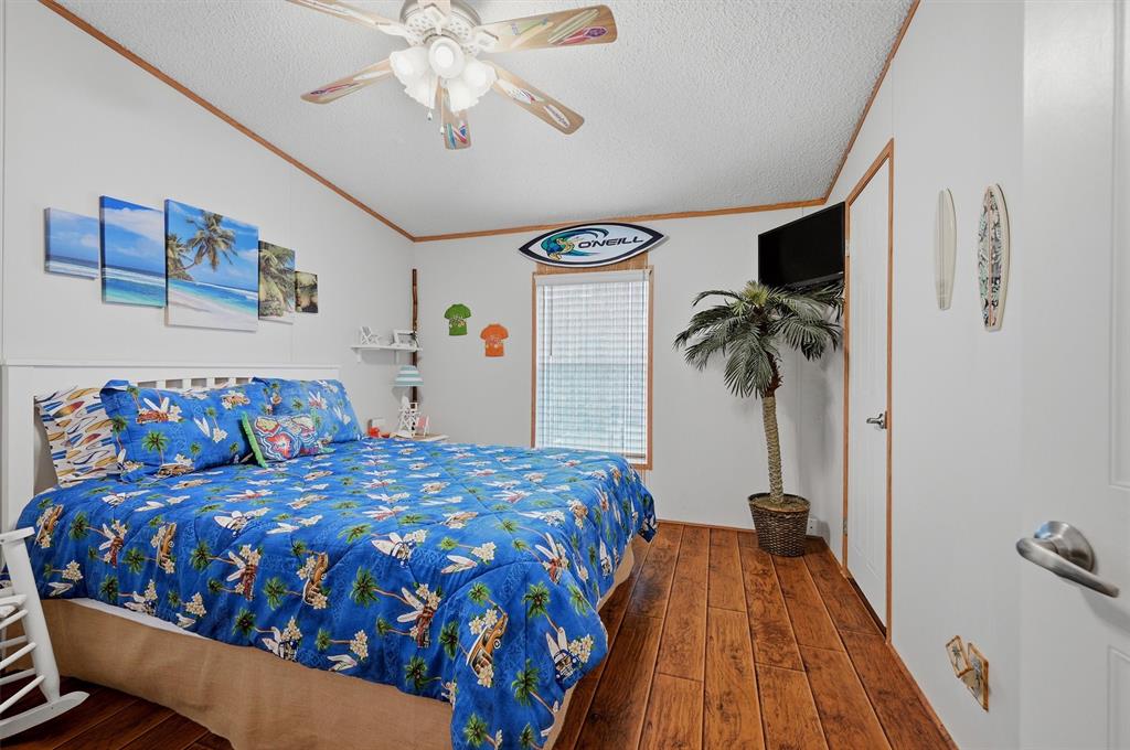 212 Sunset Road Pottsboro, TX 75076 - Photo 18 of 40 a bedroom with a bed and wooden floor