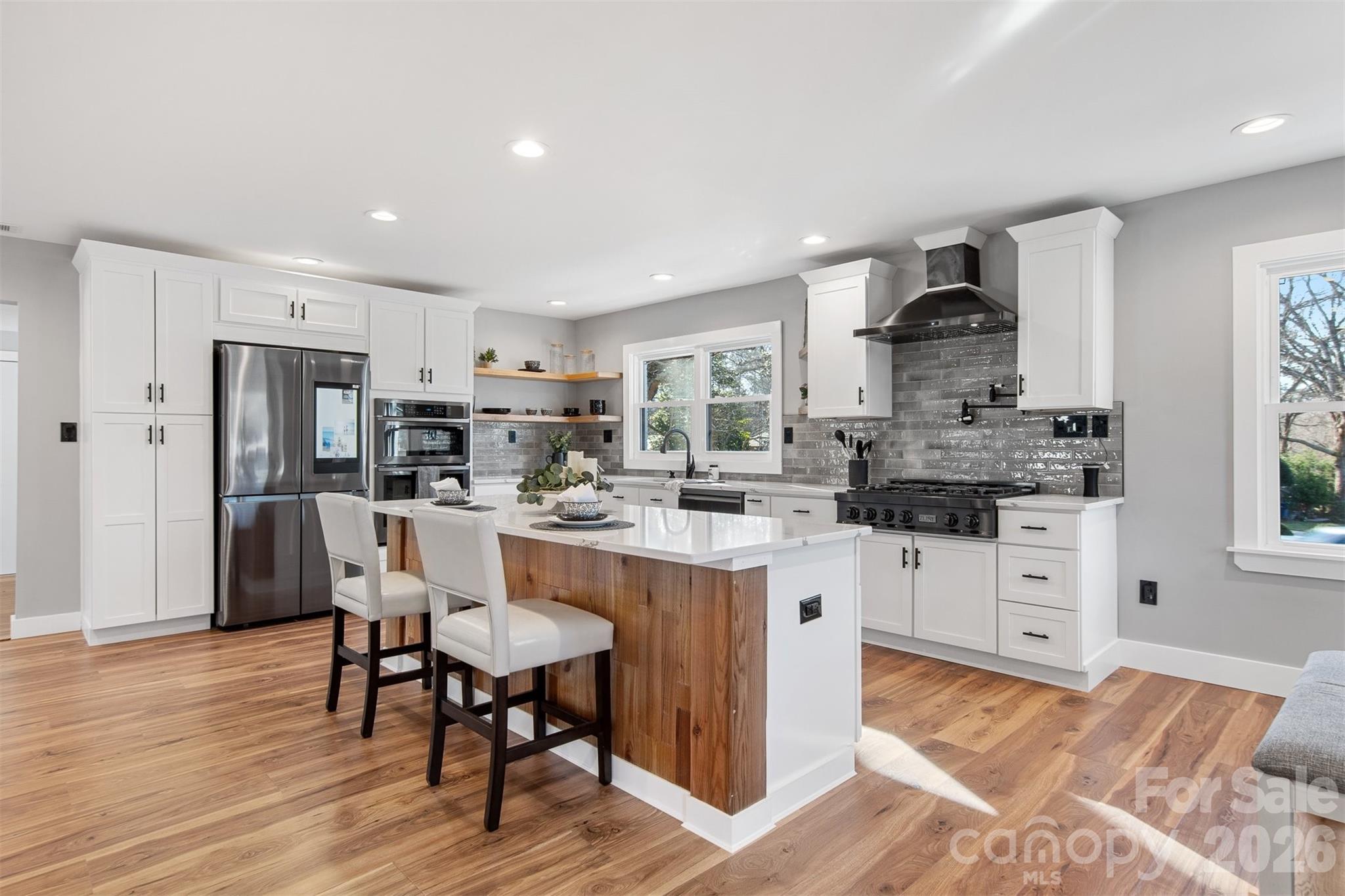 1206 9th Street Northwest Hickory, NC 28601 - Photo 9 of 40 a kitchen with white cabinets and stainless steel appliances