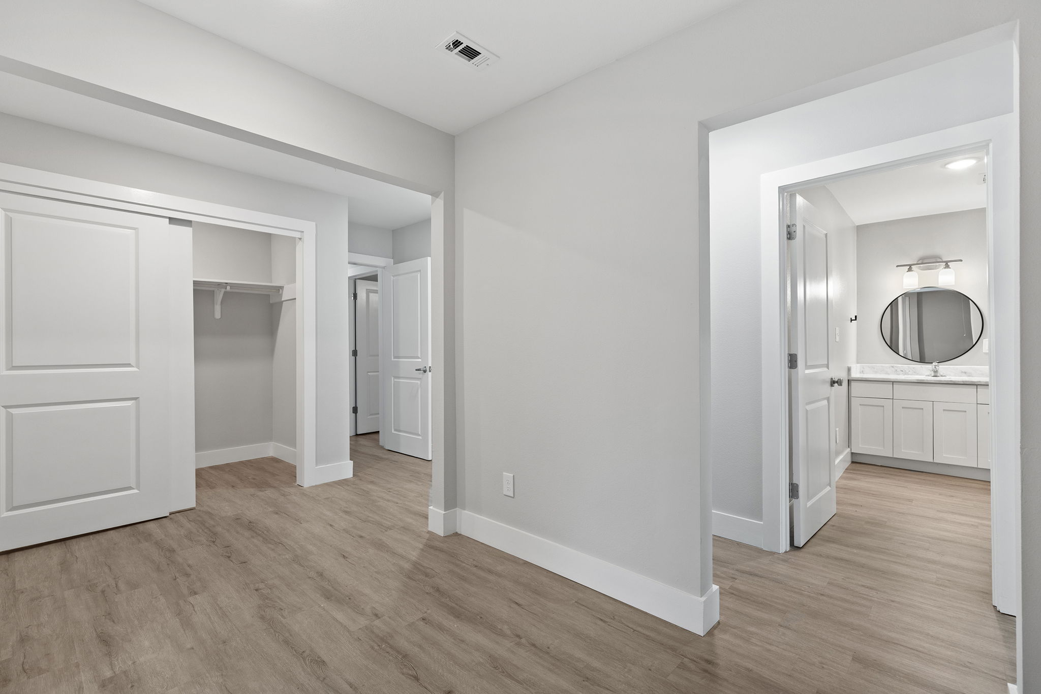 813 Central Avenue Elgin, TX 78621 - Photo 16 of 22 Unfurnished bedroom featuring light wood-style flooring, a closet, and ensuite bath