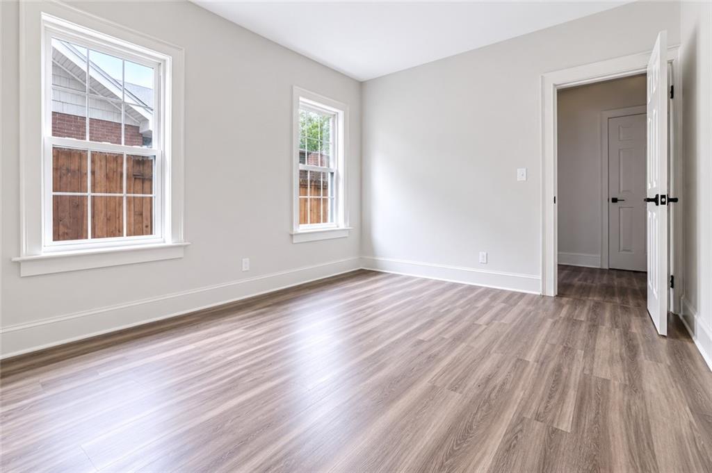 665 Lexington Avenue Southwest Atlanta, GA 30310 - Photo 14 of 33 an empty room with wooden floor and windows