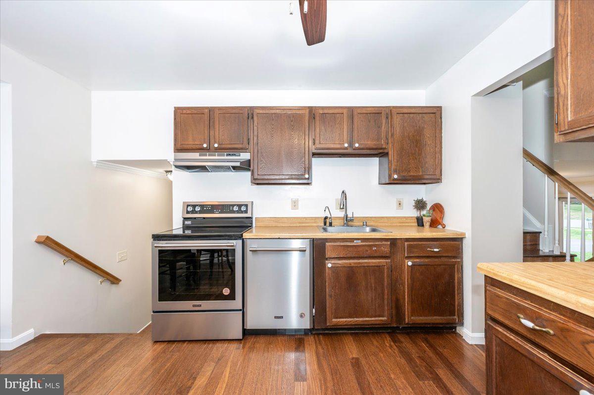 19924 Westerly Avenue Poolesville, MD 20837 - Photo 20 of 80 a kitchen with stainless steel appliances granite countertop a stove a sink dishwasher and a microwave oven with wooden floor