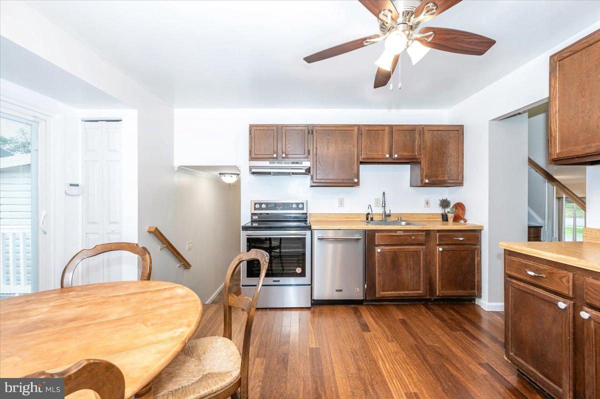 19924 Westerly Avenue Poolesville, MD 20837 - Photo 21 of 80 a kitchen with stainless steel appliances granite countertop a sink a stove top oven a chimney cabinets and wooden floor
