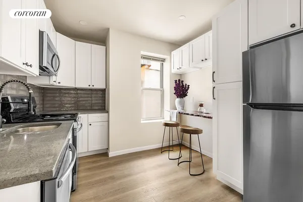 a kitchen with stainless steel appliances granite countertop a refrigerator and a stove top oven