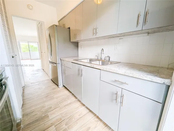 a kitchen with stainless steel appliances a sink and a refrigerator