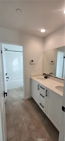 a bathroom with a double vanity sink a mirror and a shower