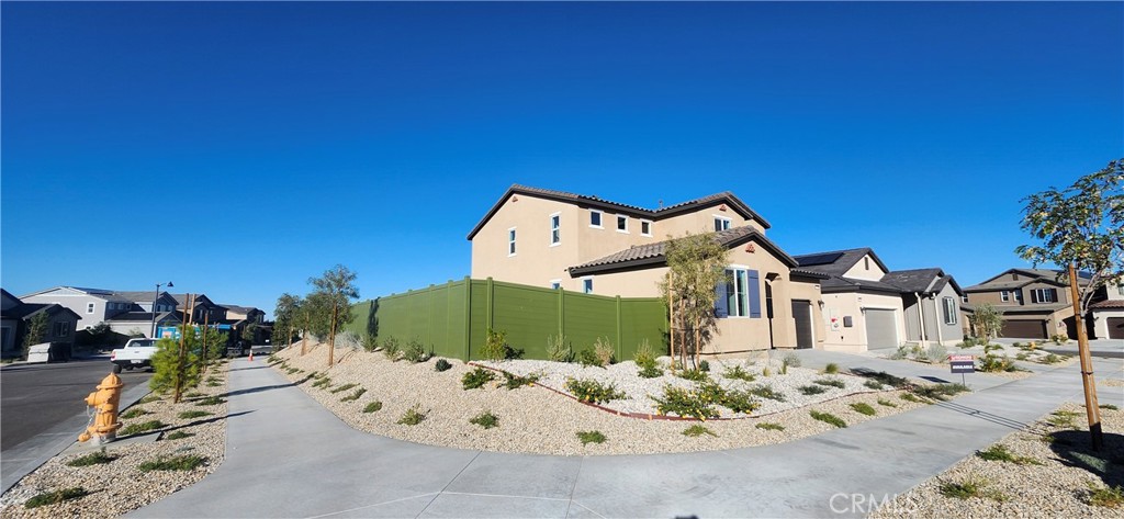 17448 Marion Mountain Hesperia, CA 92345 - Photo 2 of 12 a view of a white house with a large tree and plants