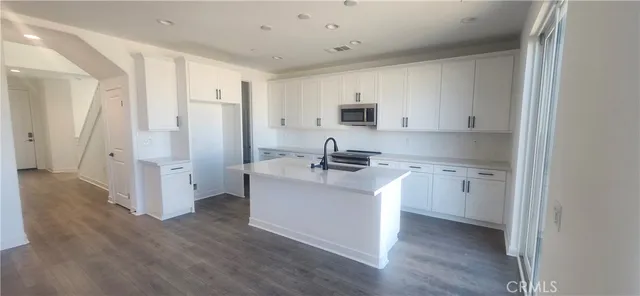a kitchen with a sink cabinets and wooden floor