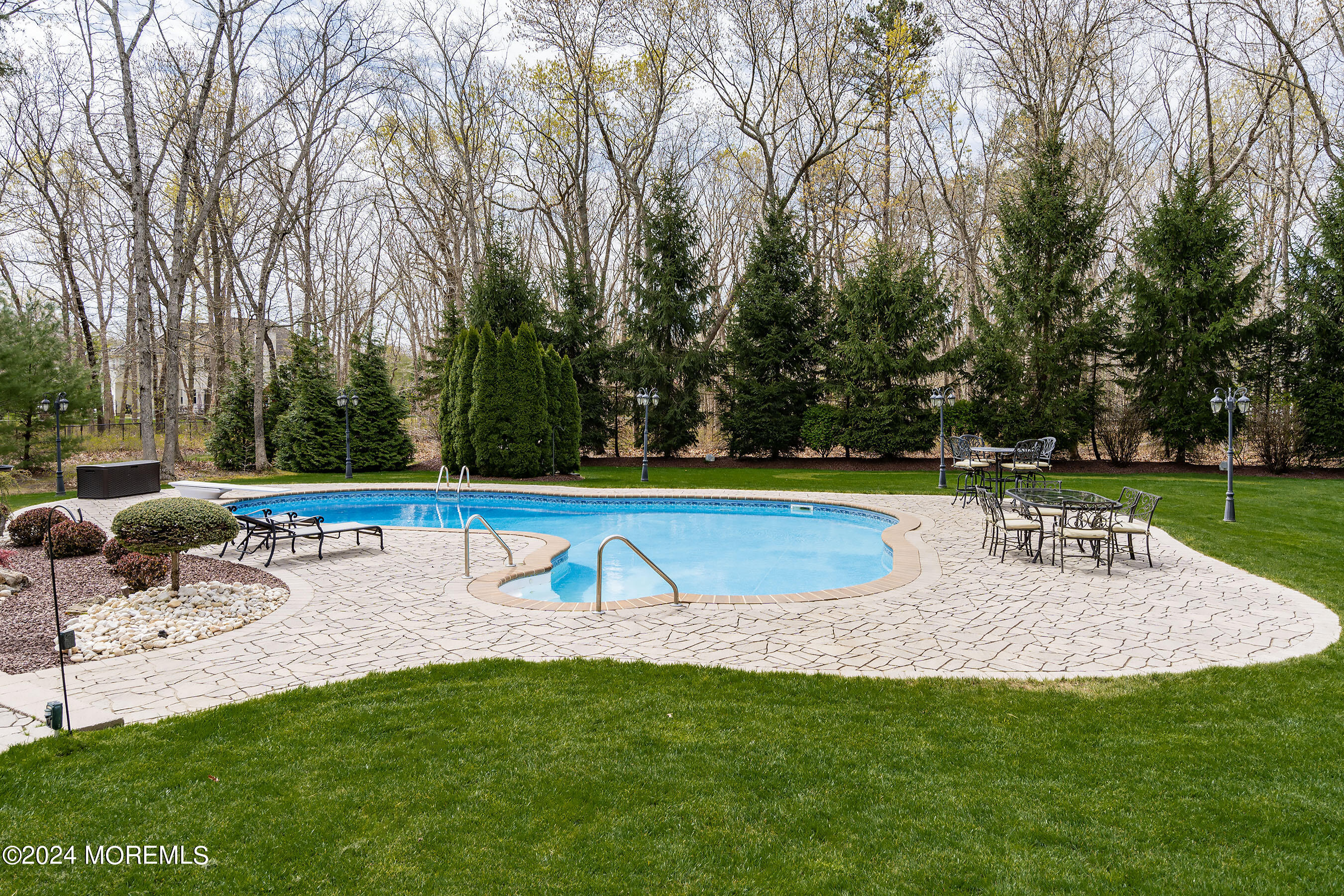 15 Summers Drive Jackson, NJ 08527 - Photo 71 of 83 a view of a swimming pool with a bench and trees in the background
