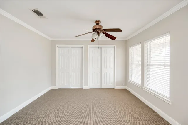 a view of empty room with window and ceiling fan
