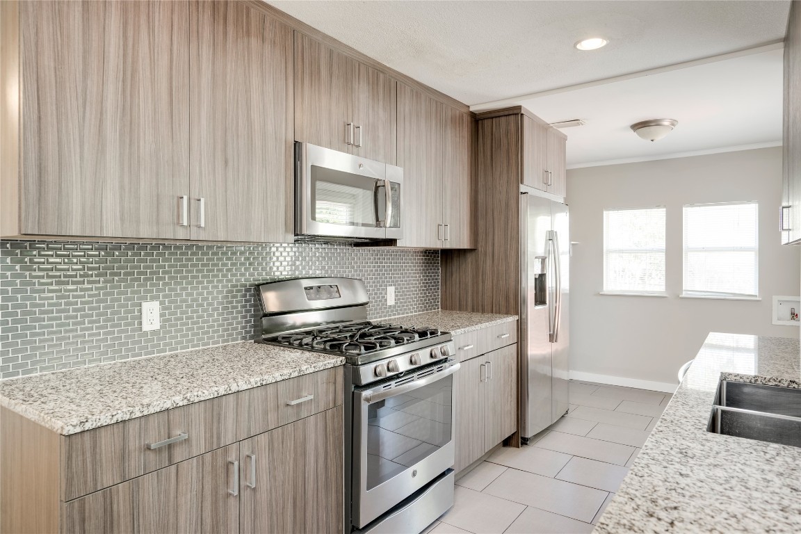 5602 Roosevelt Avenue Austin, TX 78756 - Photo 6 of 22 a kitchen with stainless steel appliances granite countertop a stove a sink and a microwave