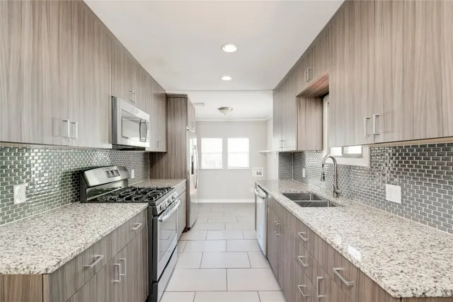 a kitchen with stainless steel appliances granite countertop a sink stove and cabinets