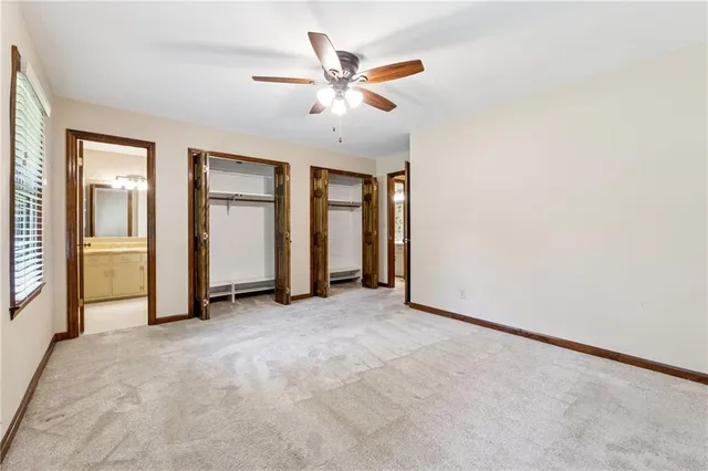 an empty room with closet and fan