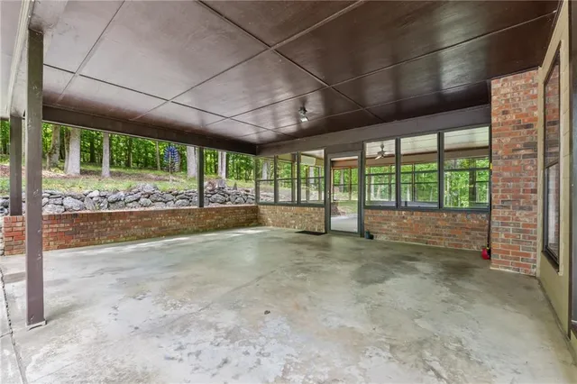 a view of an empty room with wooden floor and a sink