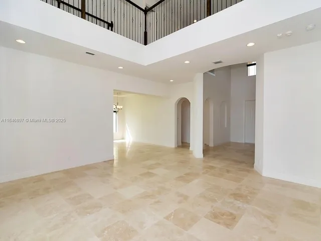 a view of an empty room with windows and entryway