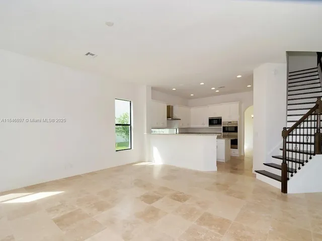 a kitchen with granite countertop white cabinets and stainless steel appliances