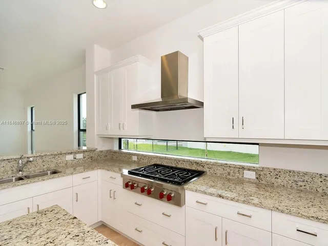 an empty room with chandelier and glass door