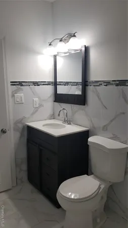 a bathroom with a sink vanity mirror and toilet