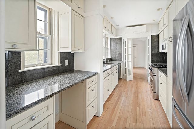 a large kitchen with a large window and stainless steel appliances