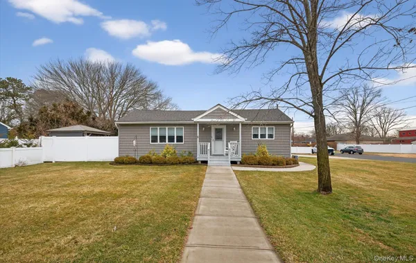 a front view of house with yard and trees
