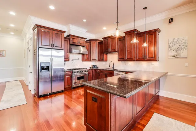 a kitchen with stainless steel appliances granite countertop a sink stove and refrigerator